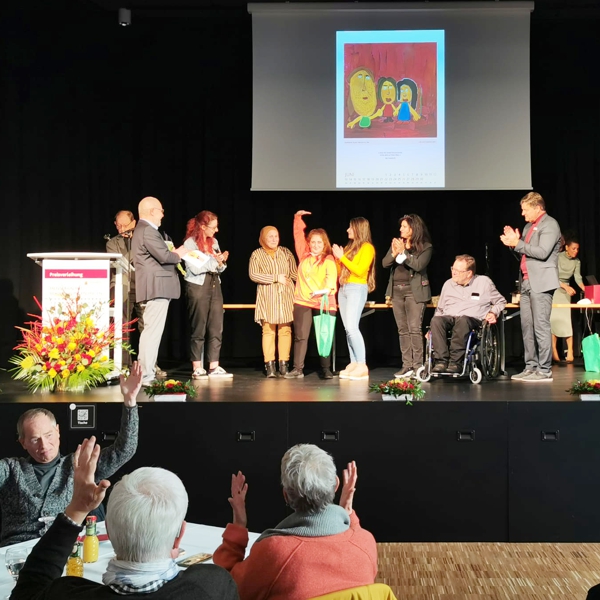 Klientin auf der Bühne nimmt Applaus entgegen