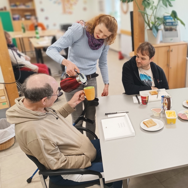 eine Gruppe der Tagesförderstätte beim gemeinsamen Frühstück