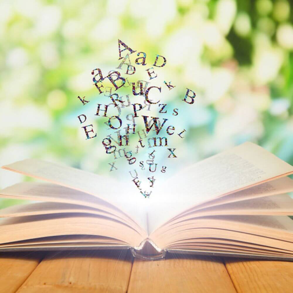 Buchstaben fliegen aus einem geöffnetem Buch