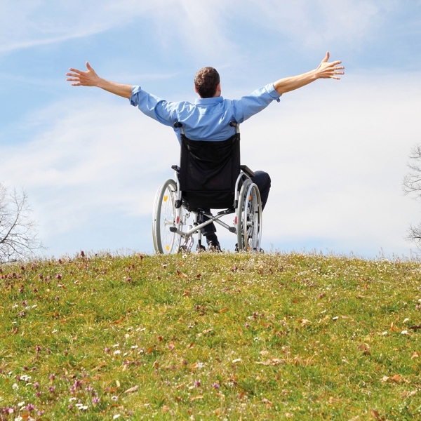 Mann im Rollstuhl vor Himmel